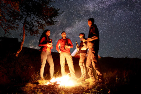 Friends roasting marshmallows around firepit in Prescott